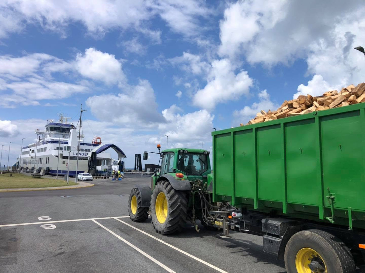 Traktor med fuldt læs brænde ved Langelandsfærgen på vej til levering